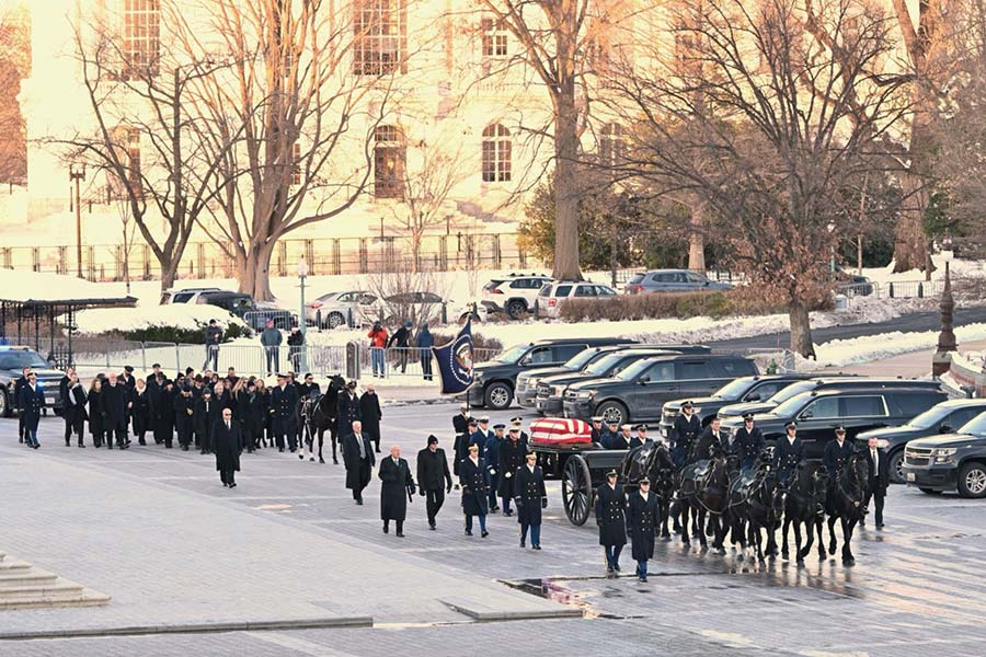 Carter family walks behind caisson