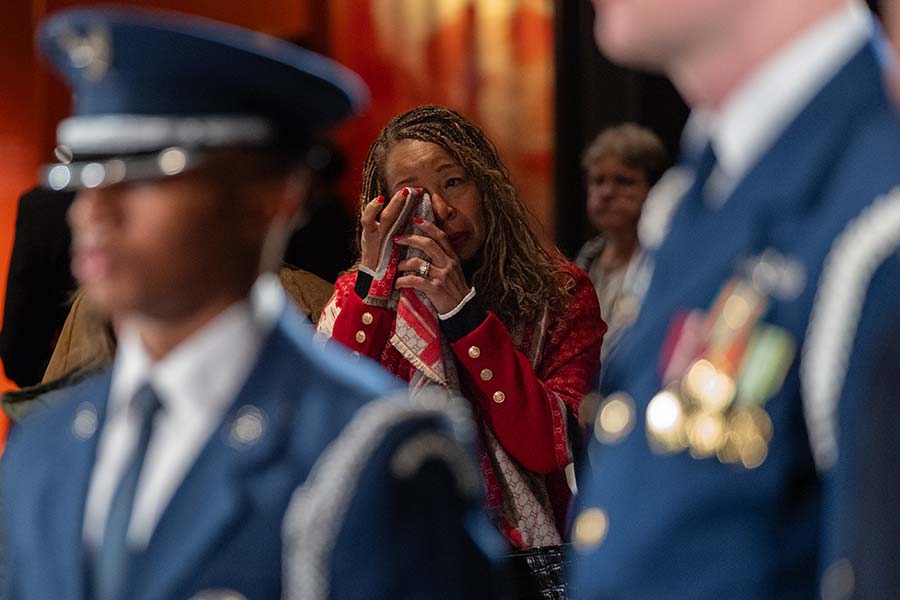 A mourner wipes her eyes.