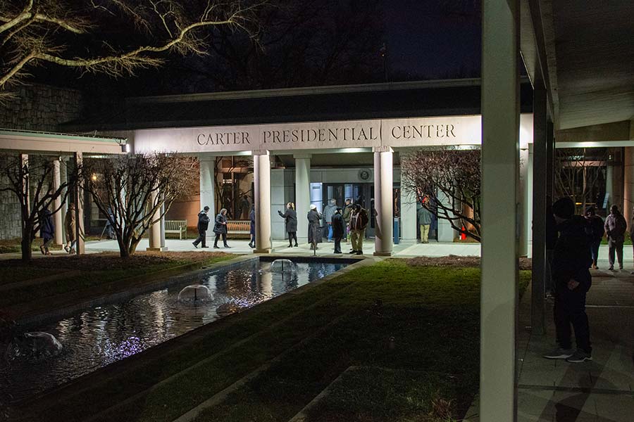 Visitors stand outside of the Carter Presidential Center,