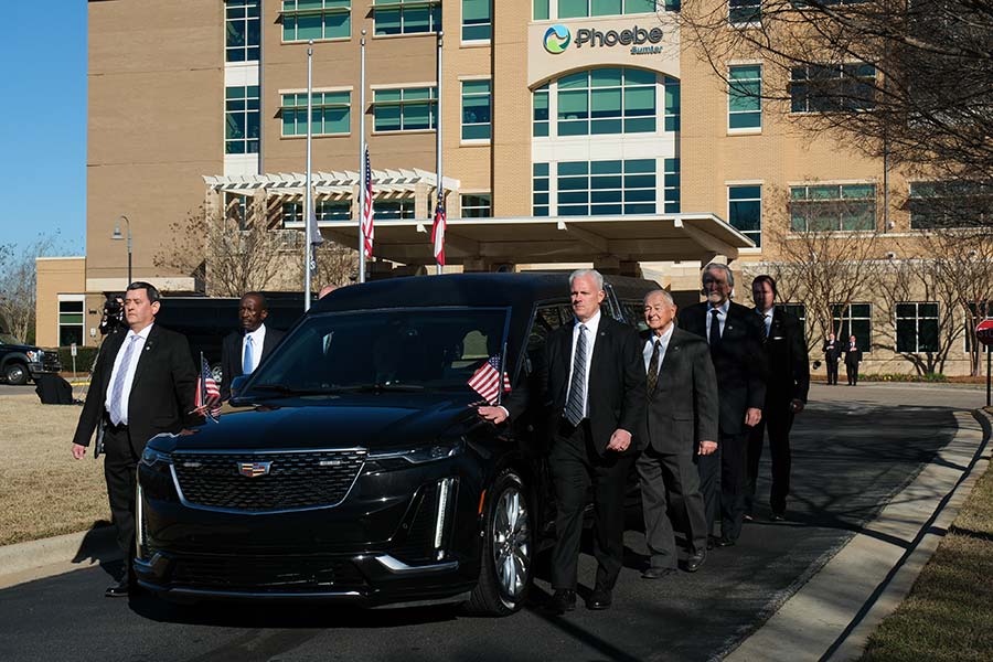 Secret Service walk along each side of the hearse.