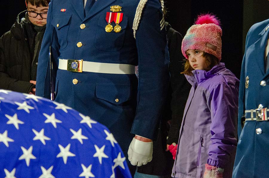 Young children look on before the casket.